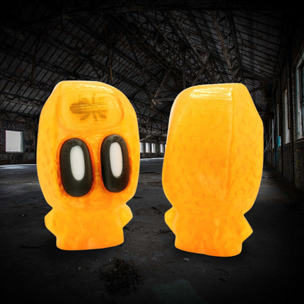Two yellow ghost-like figures with black eyes in a dark, industrial setting