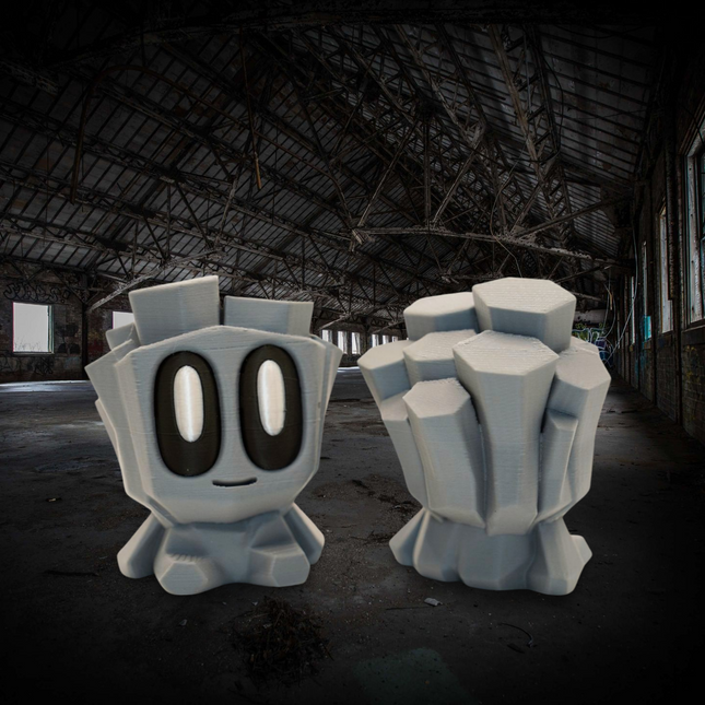 Two large, blocky character statues in a dark, dilapidated warehouse.