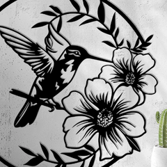 Decorative wall art with a hummingbird and flowers on a concrete wall.